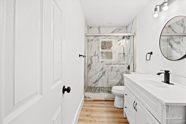 bathroom featuring hardwood / wood-style flooring, vanity, toilet, and a shower with shower door