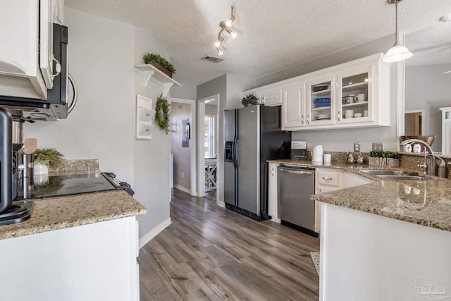 kitchen featuring dark wood-style floors, stainless steel dishwasher, a sink, fridge with ice dispenser, and a textured ceiling