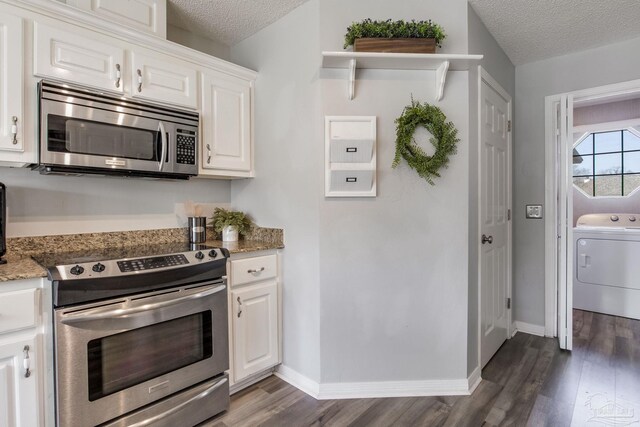 kitchen featuring dark wood-style floors, appliances with stainless steel finishes, washer / clothes dryer, a textured ceiling, and white cabinetry