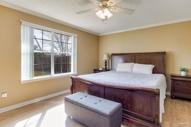 bedroom with a textured ceiling, ornamental molding, light wood-style flooring, and baseboards