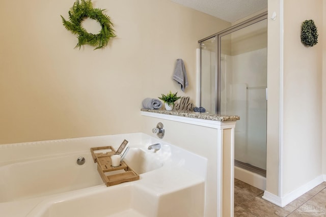 full bathroom with a textured ceiling, a stall shower, tile patterned flooring, and a bath