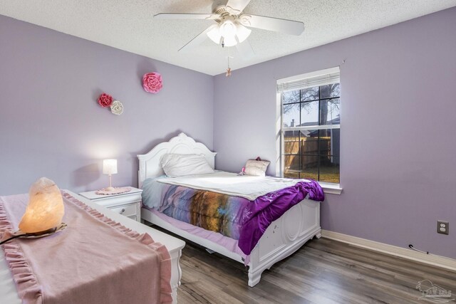 bedroom with ceiling fan, a textured ceiling, baseboards, and wood finished floors