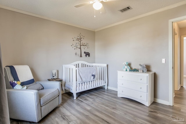 bedroom featuring ornamental molding, visible vents, and light wood-style flooring