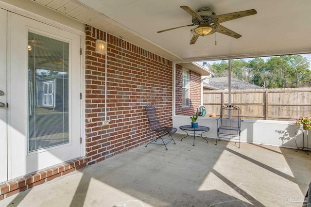 view of patio with ceiling fan and fence