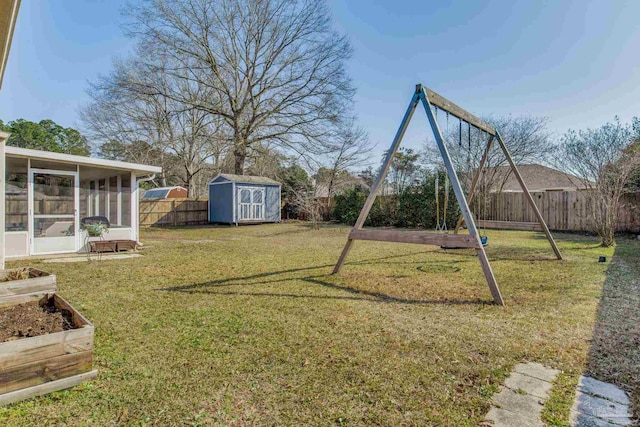 view of yard featuring a sunroom, a fenced backyard, an outbuilding, and a shed