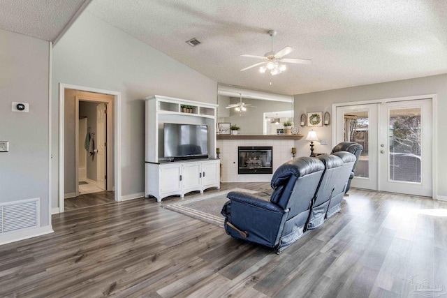 living area featuring wood finished floors, french doors, a tile fireplace, and visible vents