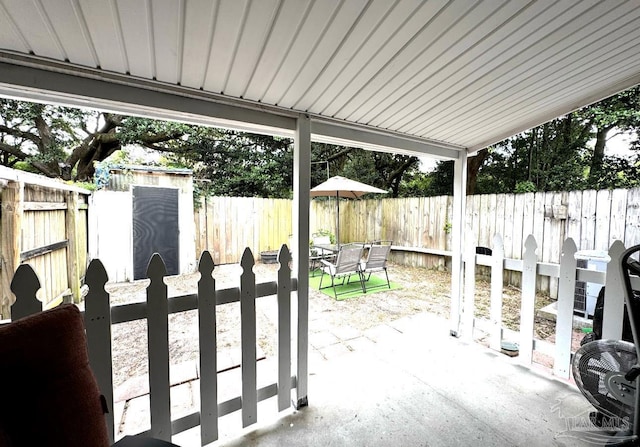 view of patio / terrace featuring a fenced backyard, an outdoor structure, and a shed