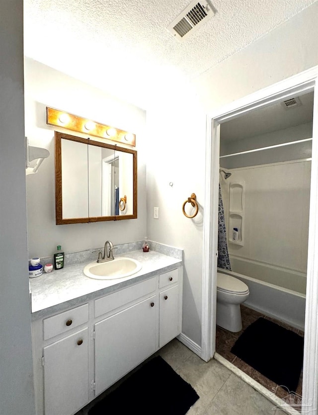 bathroom with tile patterned flooring, vanity, toilet, a textured ceiling, and visible vents