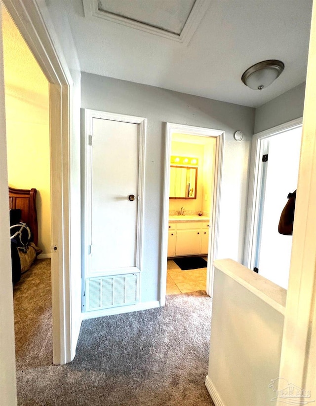 hall featuring visible vents and carpet