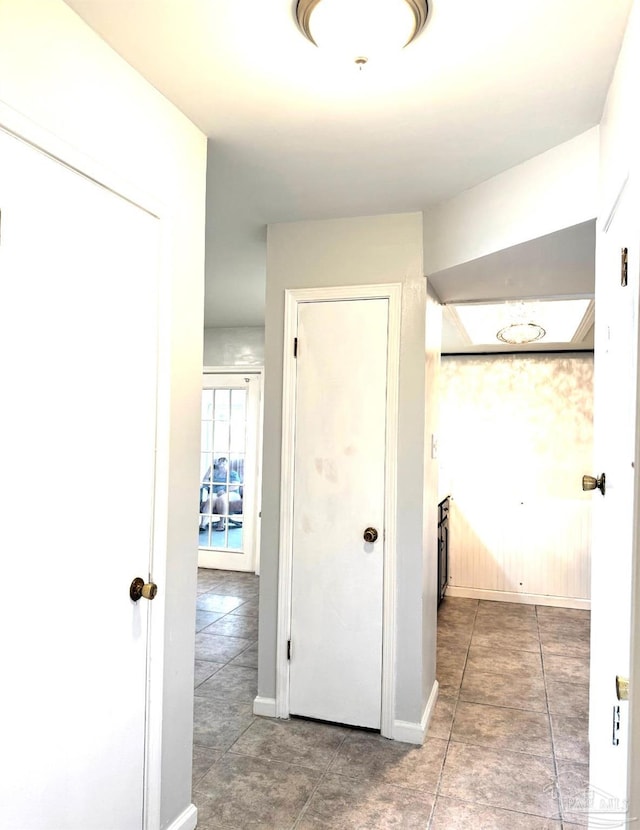 hall featuring tile patterned floors and baseboards