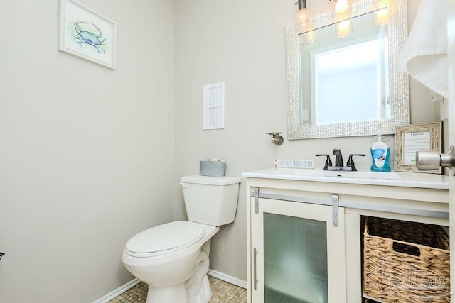 bathroom featuring vanity, toilet, and baseboards