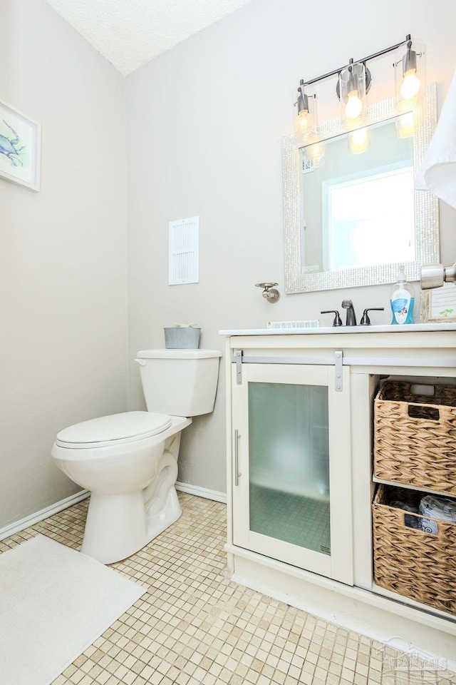 half bath with a sink, toilet, and baseboards