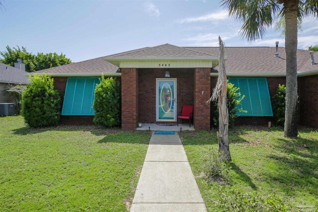 view of front facade featuring a front lawn and cooling unit