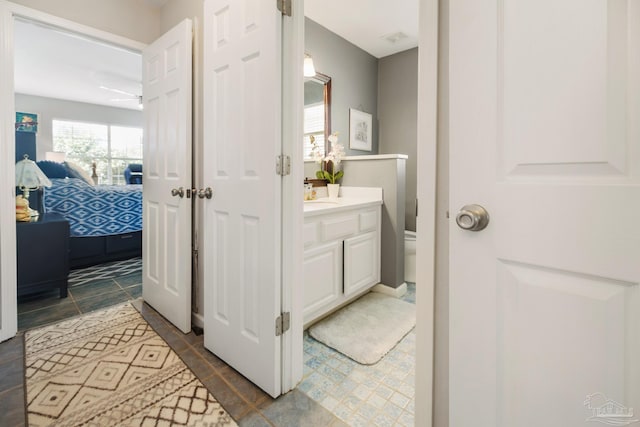 bathroom with vanity, toilet, and ceiling fan