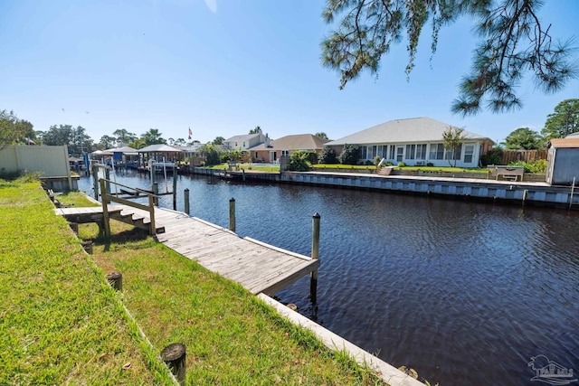 dock area featuring a lawn and a water view