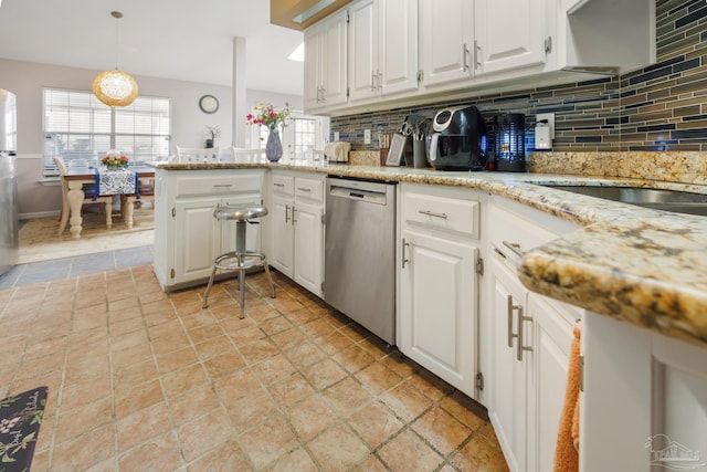 kitchen with white cabinetry, decorative light fixtures, stainless steel appliances, and backsplash