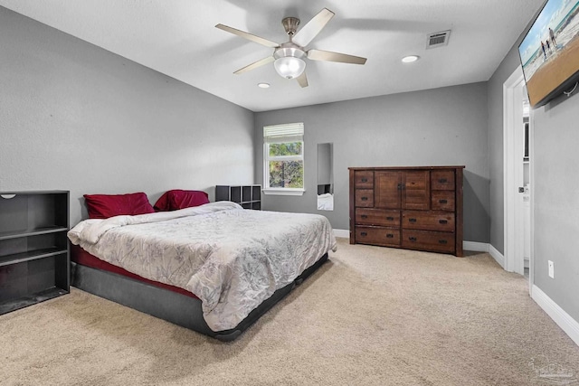 bedroom with ceiling fan and light carpet