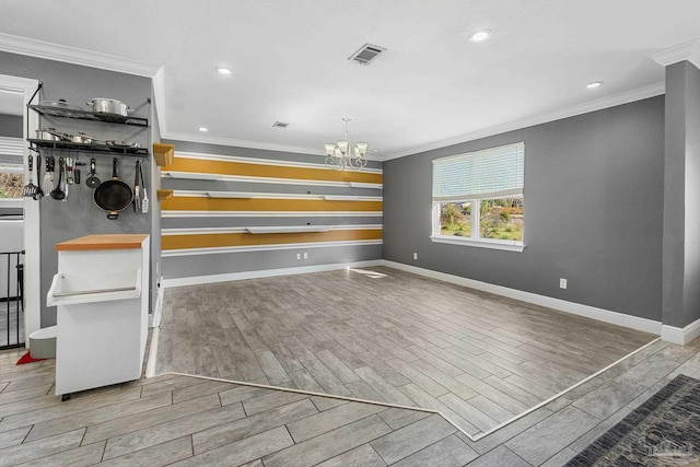 interior space with wood finish floors, visible vents, baseboards, an inviting chandelier, and crown molding