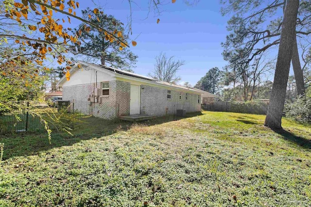 view of side of home featuring a yard and central AC unit