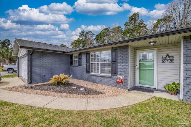 property entrance featuring an attached garage and brick siding