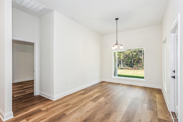 6563 Gentle Rain Dr, Milton, FL 32570 - unfurnished dining area featuring light wood-type flooring, a chandelier, and baseboards