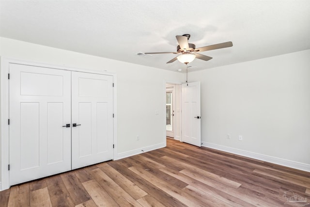 6563 Gentle Rain Dr, Milton, FL 32570 - unfurnished bedroom featuring baseboards, wood finished floors, ceiling fan, and a closet