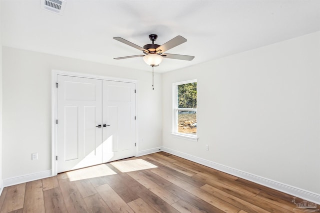 6563 Gentle Rain Dr, Milton, FL 32570 - unfurnished bedroom with baseboards, wood-type flooring, a closet, and ceiling fan