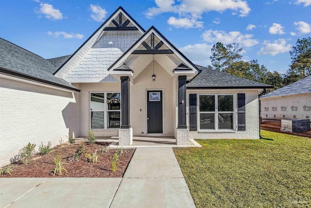 6563 Gentle Rain Dr, Milton, FL 32570 - view of front facade with a front yard, brick siding, roof with shingles, and cooling unit