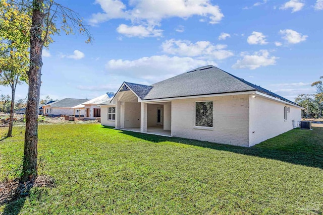 6563 Gentle Rain Dr, Milton, FL 32570 - back of house featuring a shingled roof, a lawn, a patio, and brick siding