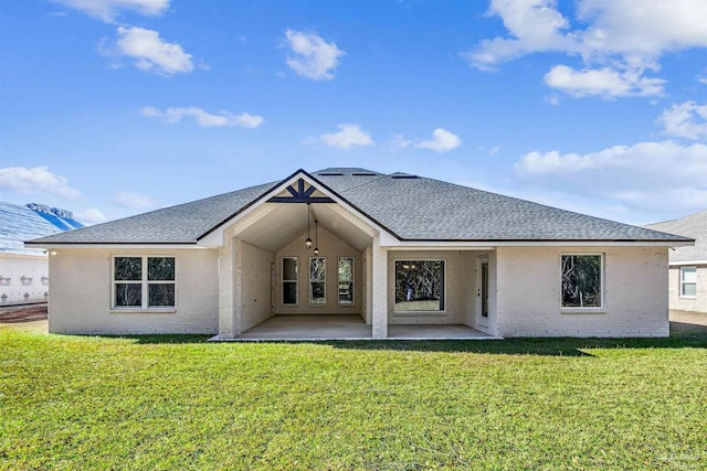 6563 Gentle Rain Dr, Milton, FL 32570 - back of house featuring brick siding, a shingled roof, a yard, and a patio