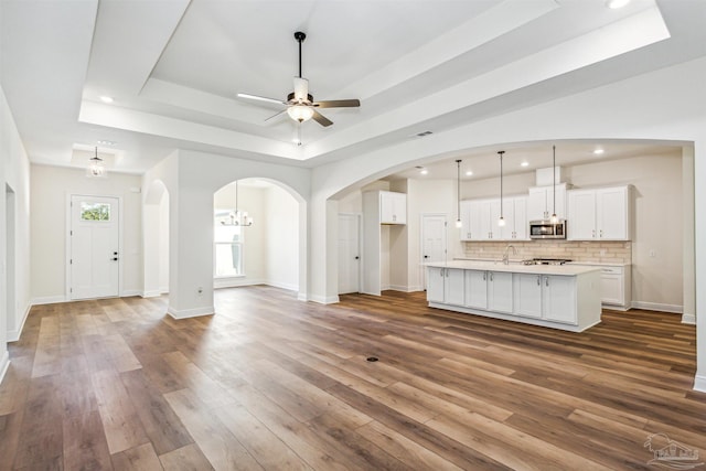 6563 Gentle Rain Dr, Milton, FL 32570 - unfurnished living room featuring a raised ceiling, a sink, recessed lighting, hardwood / wood-style floors, and ceiling fan