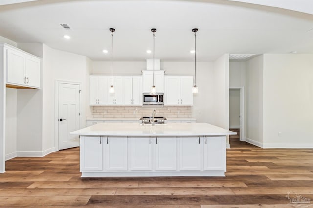 6563 Gentle Rain Dr, Milton, FL 32570 - kitchen featuring stainless steel microwave, baseboards, white cabinetry, and recessed lighting