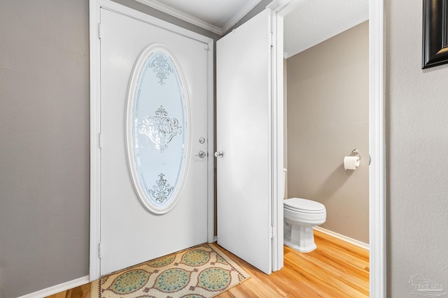 entrance foyer with hardwood / wood-style flooring, ornamental molding, and a textured ceiling