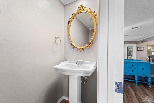 bathroom with hardwood / wood-style floors and a textured ceiling