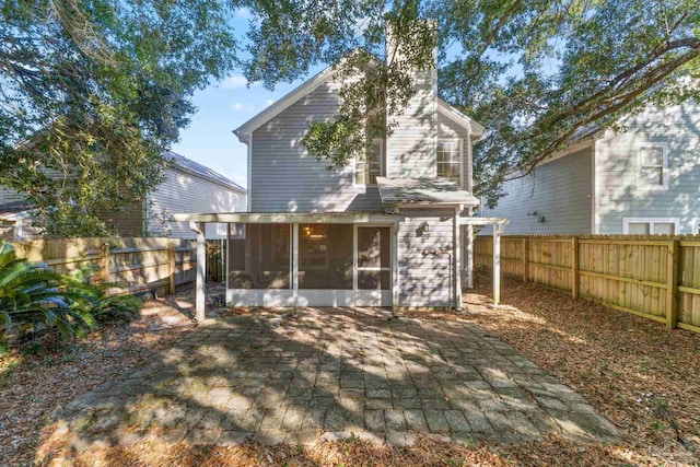 back of property with a patio and a sunroom