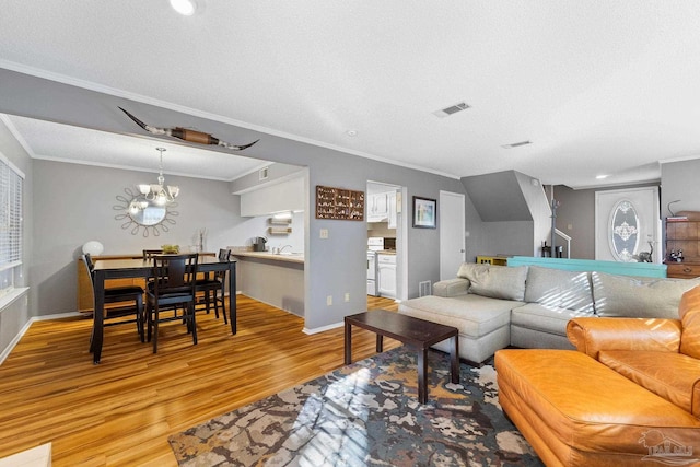 living room with sink, crown molding, light hardwood / wood-style flooring, an inviting chandelier, and a textured ceiling