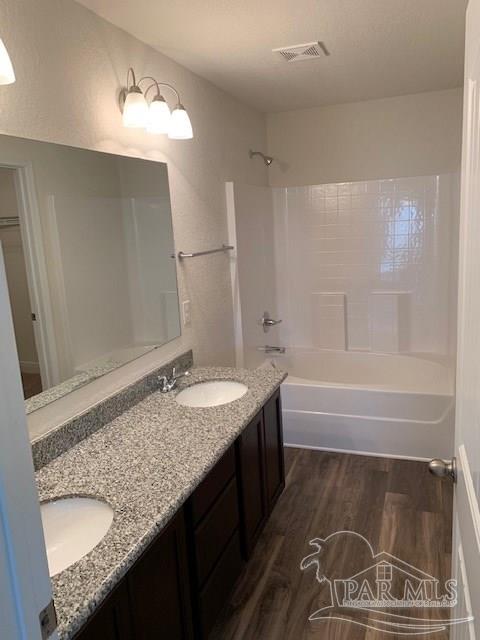 bathroom featuring hardwood / wood-style flooring, bathing tub / shower combination, and vanity