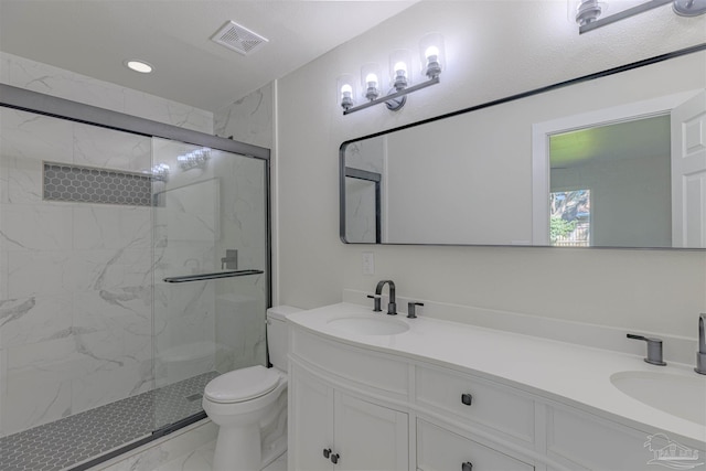 bathroom with vanity, toilet, and a shower with door