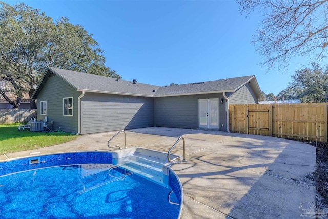 view of swimming pool featuring french doors, a patio area, and central air condition unit