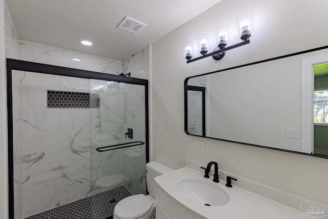 bathroom featuring vanity, toilet, a shower with door, and a textured ceiling