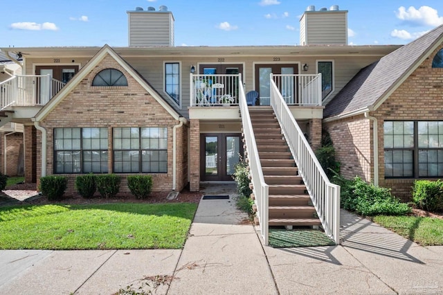 view of front facade featuring a balcony and a front lawn