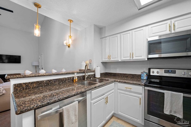 kitchen with stainless steel appliances, white cabinetry, sink, kitchen peninsula, and a textured ceiling