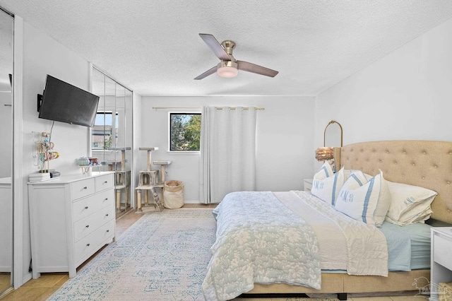 tiled bedroom with a textured ceiling and ceiling fan