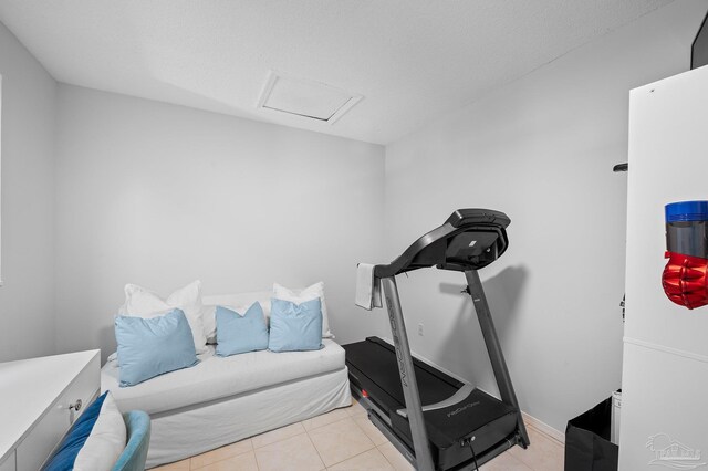 workout area featuring a textured ceiling and light tile patterned floors