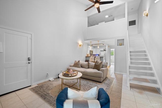 living room featuring light tile patterned flooring, a high ceiling, and ceiling fan