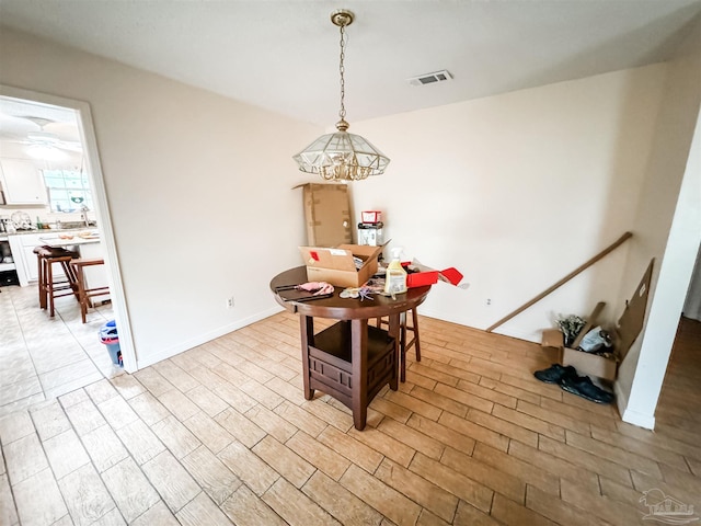 dining area featuring light hardwood / wood-style flooring and an inviting chandelier