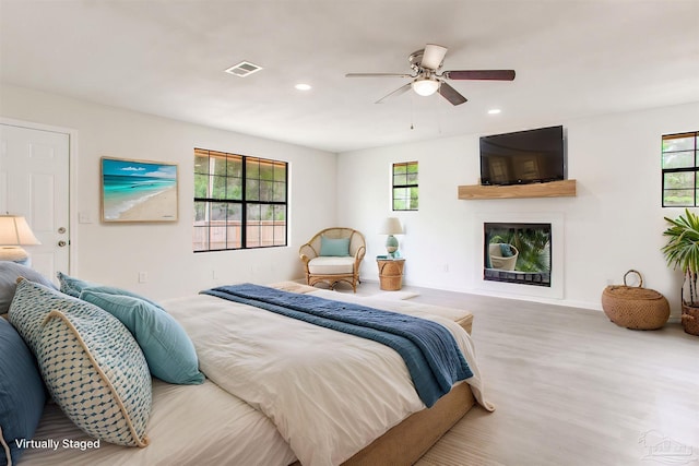8123 Mobile Hwy, Pensacola, FL 32526 - bedroom featuring multiple windows, wood finished floors, a glass covered fireplace, recessed lighting, and baseboards