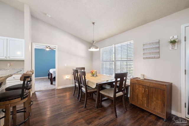 dining area featuring vaulted ceiling, dark wood-type flooring, ceiling fan, and a textured ceiling