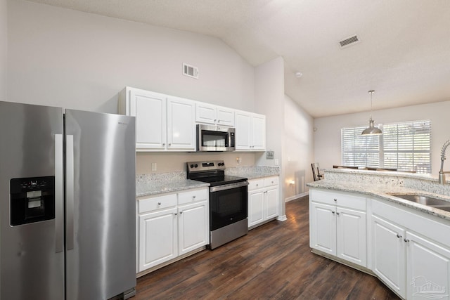 kitchen featuring lofted ceiling, sink, white cabinetry, hanging light fixtures, and stainless steel appliances