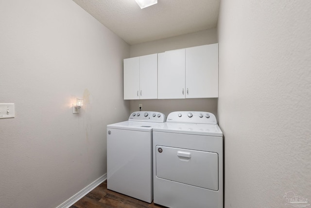 laundry area featuring cabinets, dark hardwood / wood-style flooring, a textured ceiling, and independent washer and dryer